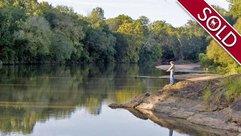 Man fishing on river bank